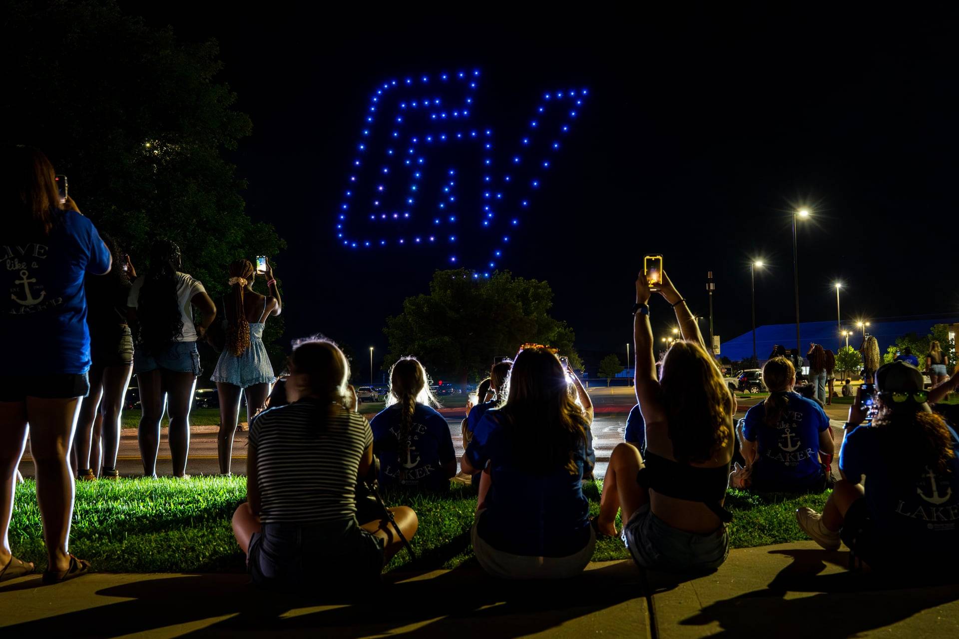 drones in shape of GV, students sitting watching show